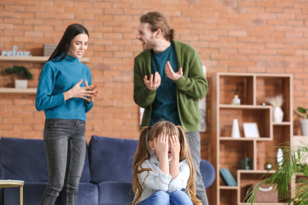 Itkevä pieni tyttö ja hänen riitaa vanhemmat kotona - Valokuva, kuva