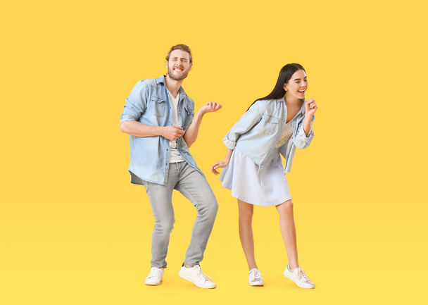 Happy young couple dancing on color background - Zdjęcie, obraz