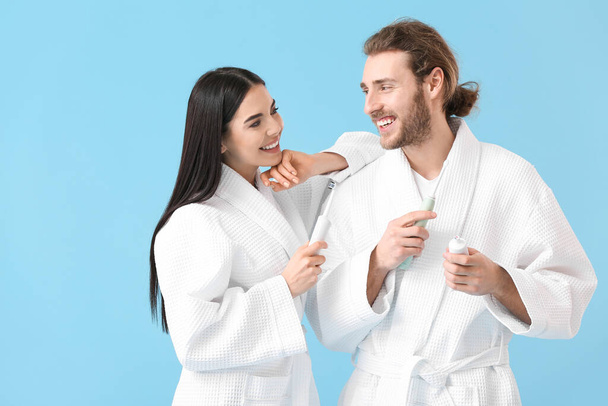 Junges Paar beim Zähneputzen auf farbigem Hintergrund - Foto, Bild
