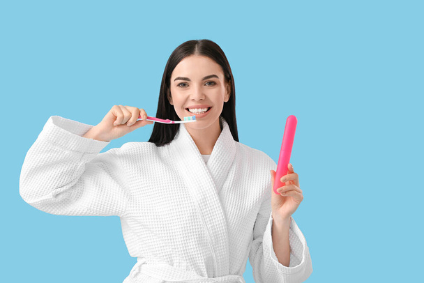 Młoda kobieta myje zęby na tle koloru - Zdjęcie, obraz