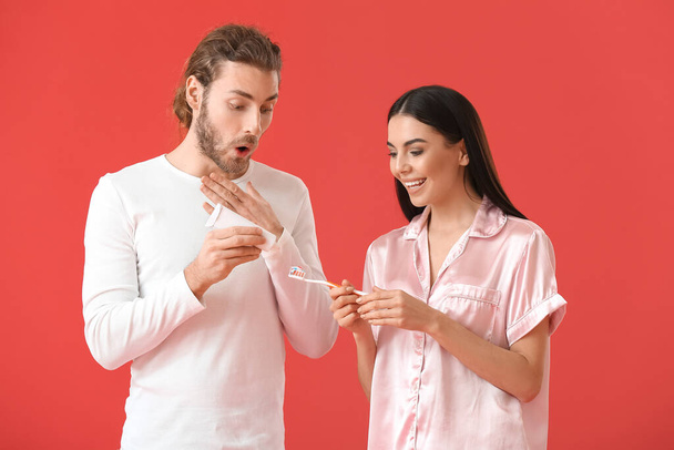 Young couple brushing teeth on color background - Photo, Image