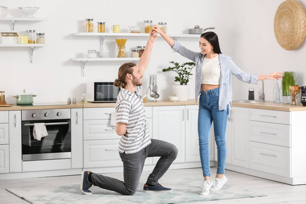szczęśliwy młody para taniec w kuchnia - Zdjęcie, obraz