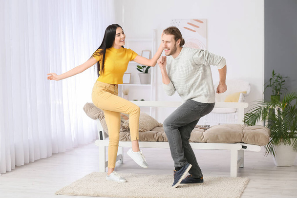 Щаслива молода пара танцює вдома
 - Фото, зображення