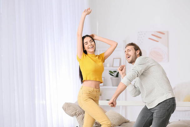 Ευτυχισμένο νεαρό ζευγάρι που χορεύει στο σπίτι - Φωτογραφία, εικόνα