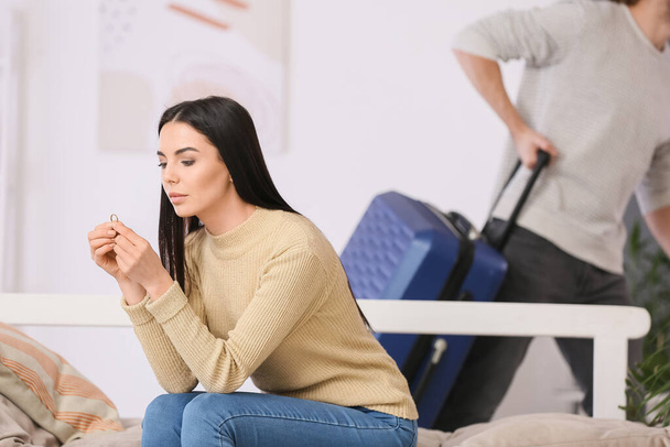 Upset woman and her husband with suitcase going to leave family - Foto, Imagen