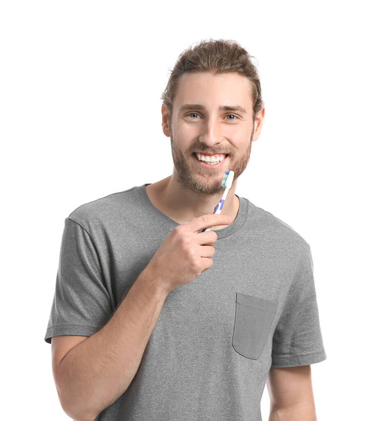 Handsome man brushing teeth on white background - Foto, afbeelding