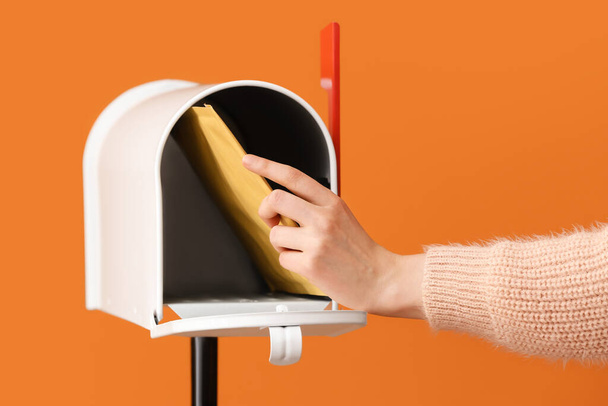 Woman getting letter from box on color background - Foto, afbeelding