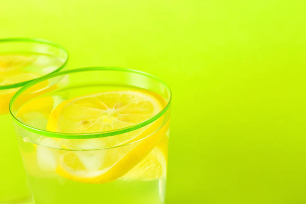 Szklanki smacznej zimnej lemoniady na tle koloru, zbliżenie - Zdjęcie, obraz