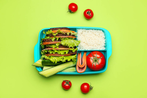 Ebéddoboz ízletes ételek színes háttér - Fotó, kép