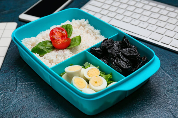 Almuerzo con sabrosa comida y teclado sobre fondo oscuro - Foto, Imagen