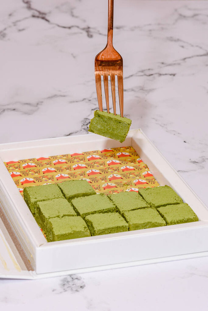 Nama Matcha Chocolate On A White Marble Countertop With A Fork Picking Out A Piece. Image can be utilized editorially or commercially. - 写真・画像
