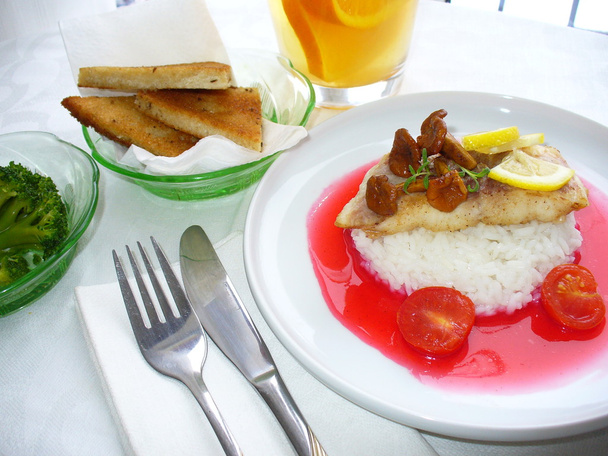 Plato de lucio perca con arroz, champiñones, salsa, limón, tostadas
 - Foto, imagen