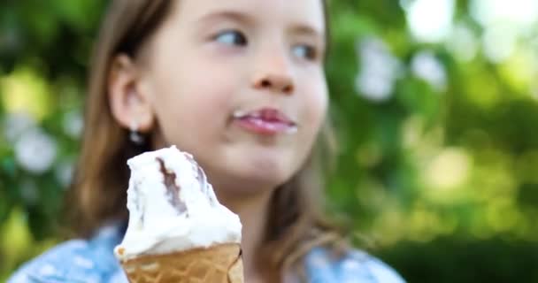 Menina bonito comer italiano sorvete cone sorrindo enquanto descansa no parque no dia de verão - Filmagem, Vídeo