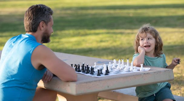Happy family outdoor. Father and son playing chess in summer garden. Games and activities for children. - Fotoğraf, Görsel