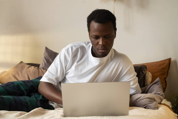 African man surfing the internet in his room at home - Zdjęcie, obraz