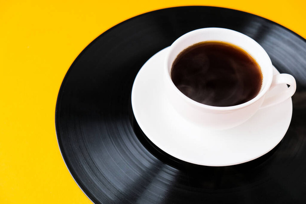 Cup of black coffee on vynil record. Copy space. Listening to music. Retro style. Podcast. - Photo, Image
