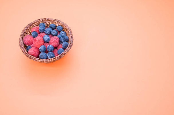 A closeup shot of blueberries raspberries in a basket - Fotografie, Obrázek