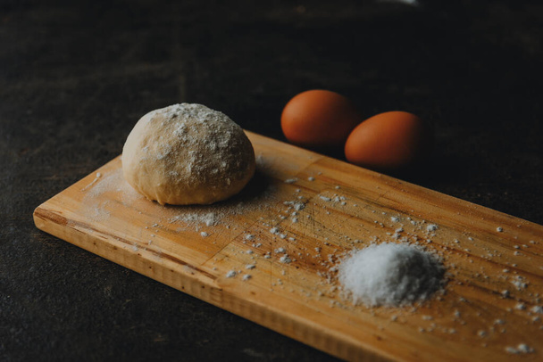 A closeup shot of salt, dough, and eggs on a table - Foto, afbeelding