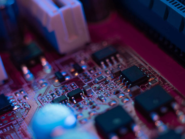 Computer motherboard, microchips close-up in color illumination, - Fotó, kép