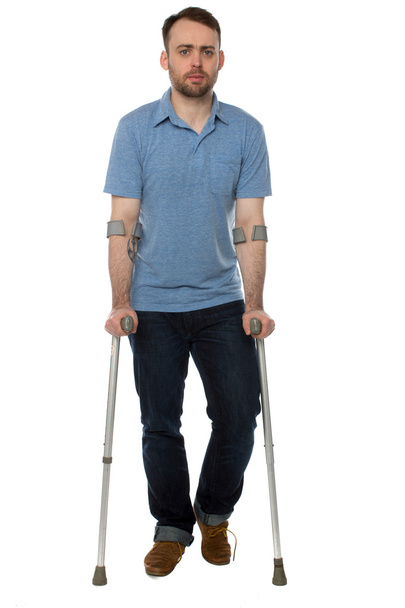 若い男の前腕松葉杖で歩く無効になっています。 - 写真・画像