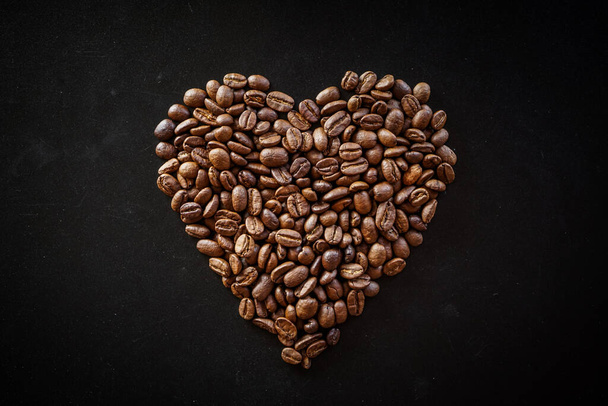 coração feito de grãos de café no fundo preto  - Foto, Imagem
