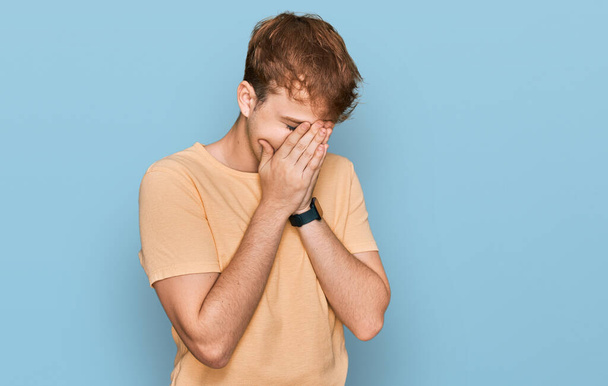 Jonge blanke man draagt casual kleding met droevige uitdrukking bedekken gezicht met handen tijdens het huilen. depressie concept.  - Foto, afbeelding