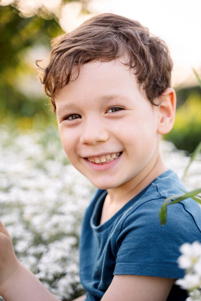 a boy in flowers, a child among the bushes - Fotografie, Obrázek