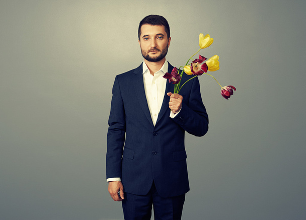 schöner Mann mit verblassten Blumen über dunklem - Foto, Bild
