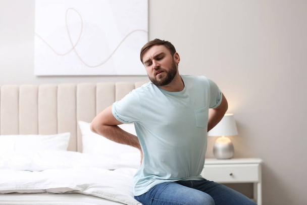 家で腰痛に苦しむ男。姿勢の悪い問題 - 写真・画像