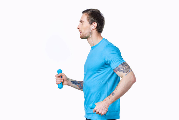 athletic man with dumbbells goes in for sports jogging white background side view - 写真・画像