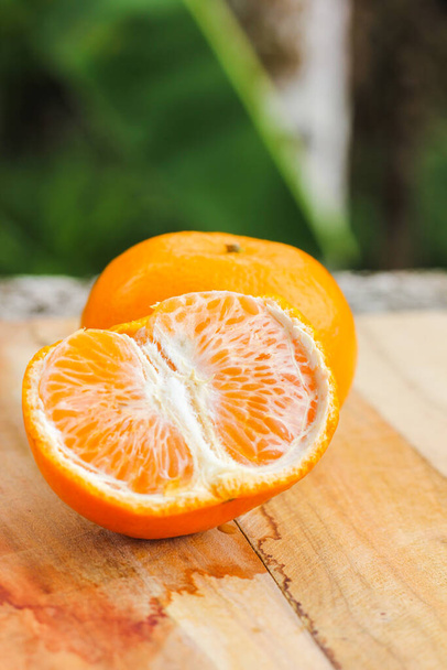 木のテーブルの上のオレンジフルーツ - 写真・画像