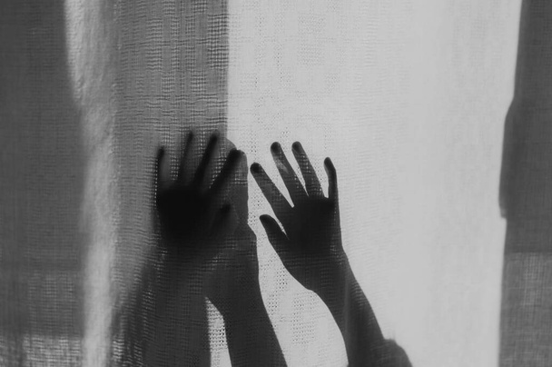 Hands defocused silhouetted dark shadow on a light background - Photo, Image