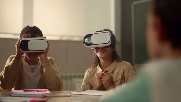 Estudiantes en gafas vr aprendiendo en la escuela. Niños inmersos en la realidad virtual - Foto, imagen