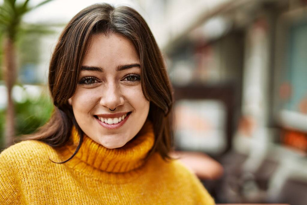 Junge schöne brünette Frau trägt Rollkragenpullover und lächelt glücklich im Freien - Foto, Bild