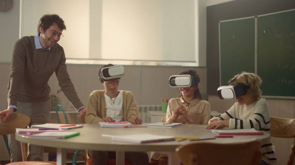 Öğretmenim sınıfta 3D VR gözlüklü öğrencilerle etkileşimli ders alıyor. - Fotoğraf, Görsel