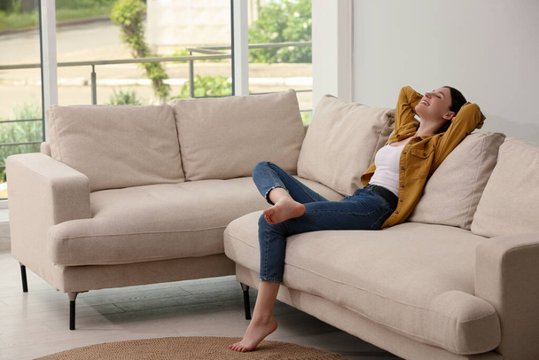 Teenage girl relaxing on sofa at home - Foto, afbeelding