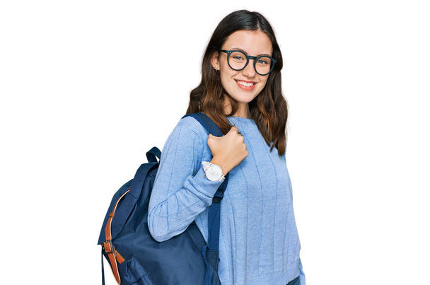 Junge schöne Mädchen mit Studenten-Rucksack sieht positiv und glücklich stehend und lächelnd mit einem selbstbewussten Lächeln Zähne zeigen  - Foto, Bild