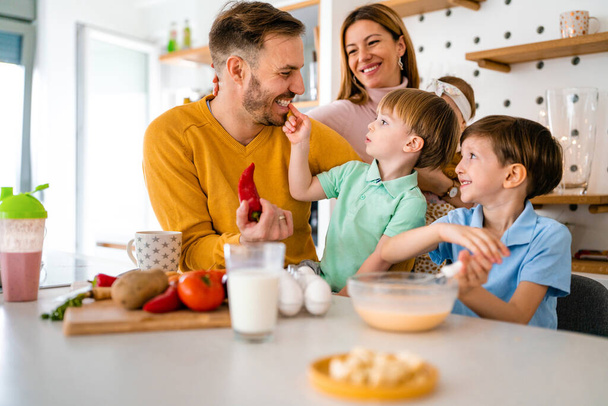 Happy family in the kitchen having fun and cooking together. Healthy food at home. - Foto, Imagem