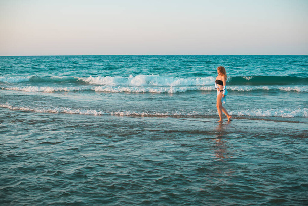 Mujer europea con caderas suculentas descansando en la playa junto al mar demostró su figura en traje de baño  - Foto, Imagen