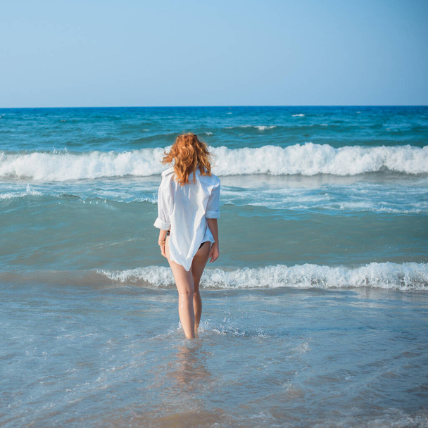 Mulher europeia com quadris suculentos completos descansando na praia junto ao mar demonstrou sua figura em trajes de banho  - Foto, Imagem