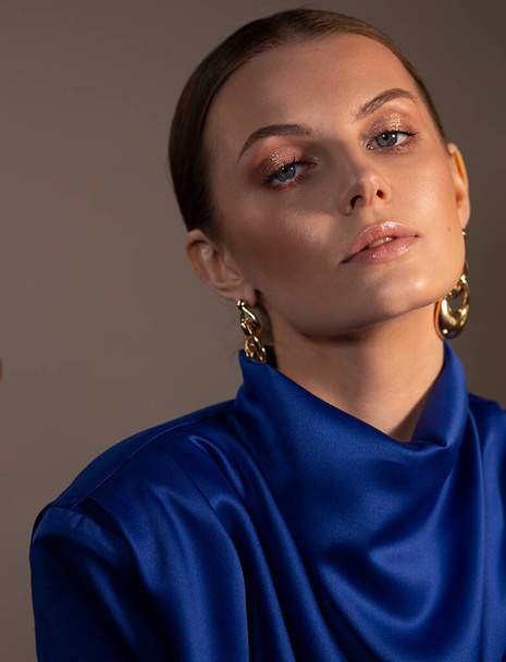 Elegant woman. Portrait. Evening look. Stylish silk blouse for women. Large Gold Earrings. Slicked-back hair. - Photo, image