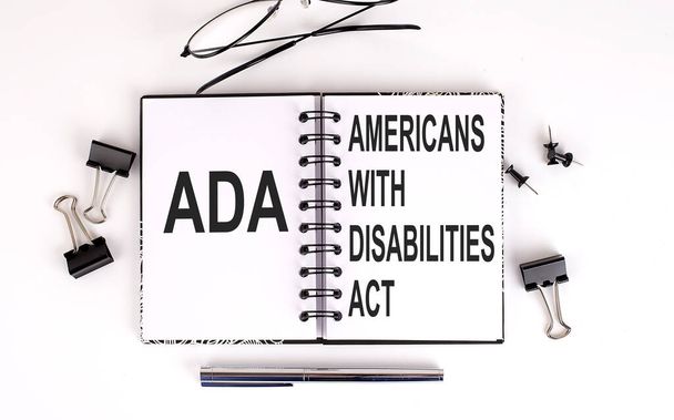 Cuaderno con la Ley ADA de Estadounidenses con Discapacidades sobre la mesa - Foto, imagen