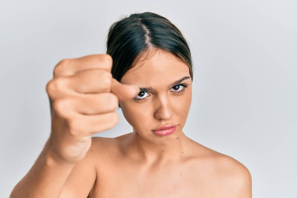 Fiatal barna nő áll félmeztelenül mutatja bőr bosszús és frusztrált kiabál a harag, kiabál őrült a harag és a kéz emelt  - Fotó, kép