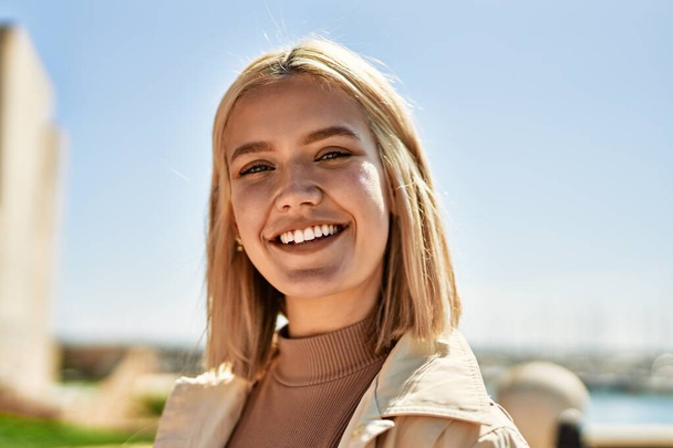 Young blonde girl smiling happy standing at the city. - Foto, Imagem