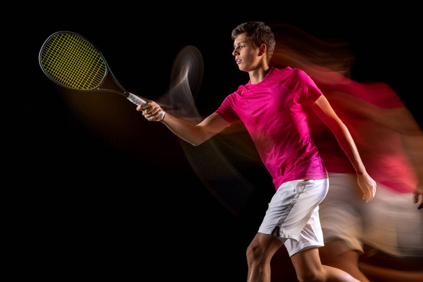 One man, male tennis player training isolated in mixed neon light on dark background. Concept of sport, team competition. - Фото, зображення