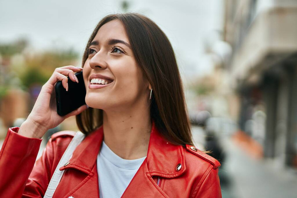 Young hispanic woman smiling happy talking on the smartphone at the city. - Foto, Imagen