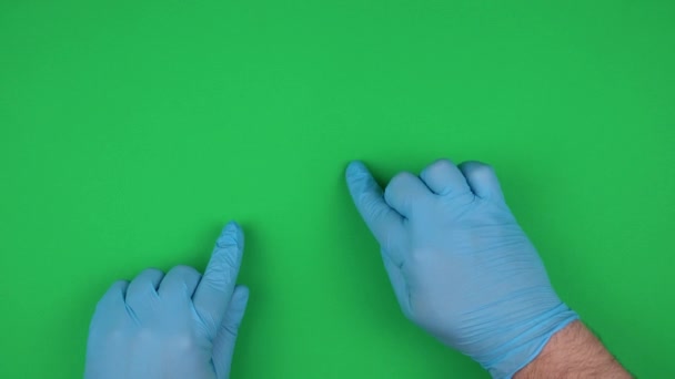 χέρια σε ιατρικά γάντια κινούνται σε μια αφηρημένη οθόνη. κίνηση δακτύλου. τη λειτουργία της συσκευής σύμφωνα με τα πρότυπα υγιεινής. πάνω όψη, χρωματικό κλειδί - Πλάνα, βίντεο