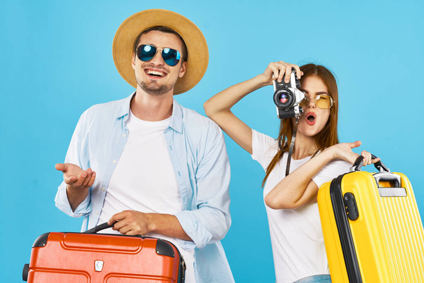 alegre joven pareja con maletas viaje vacaciones divertido fondo azul - Foto, Imagen