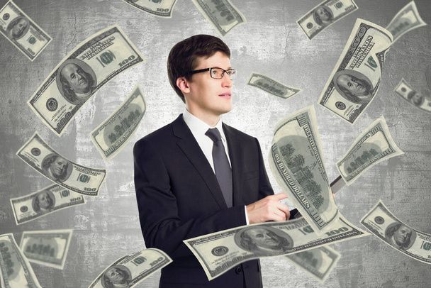Leadership and winner concept with businessman surrounded by us dollars bills on abstract background - Фото, зображення