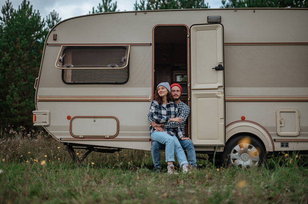 Romantisch stel brengt tijd samen door in de buurt van woonwagen. Samen met de camper reizen. - Foto, afbeelding